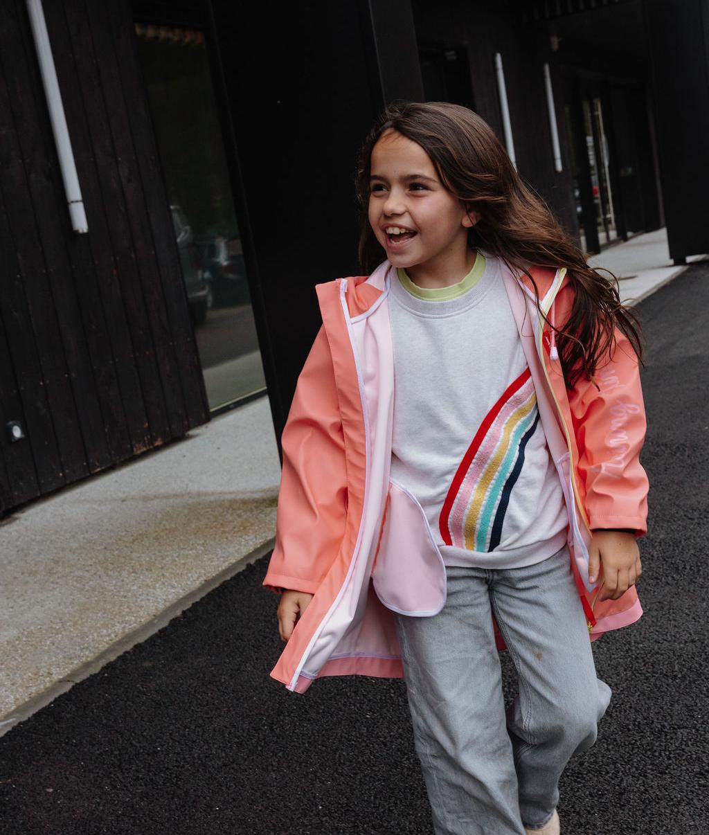 Menina a usar o impermeável de chuva com capuz Pink, sem fecho – foto lifestyle – Hello Hossy
