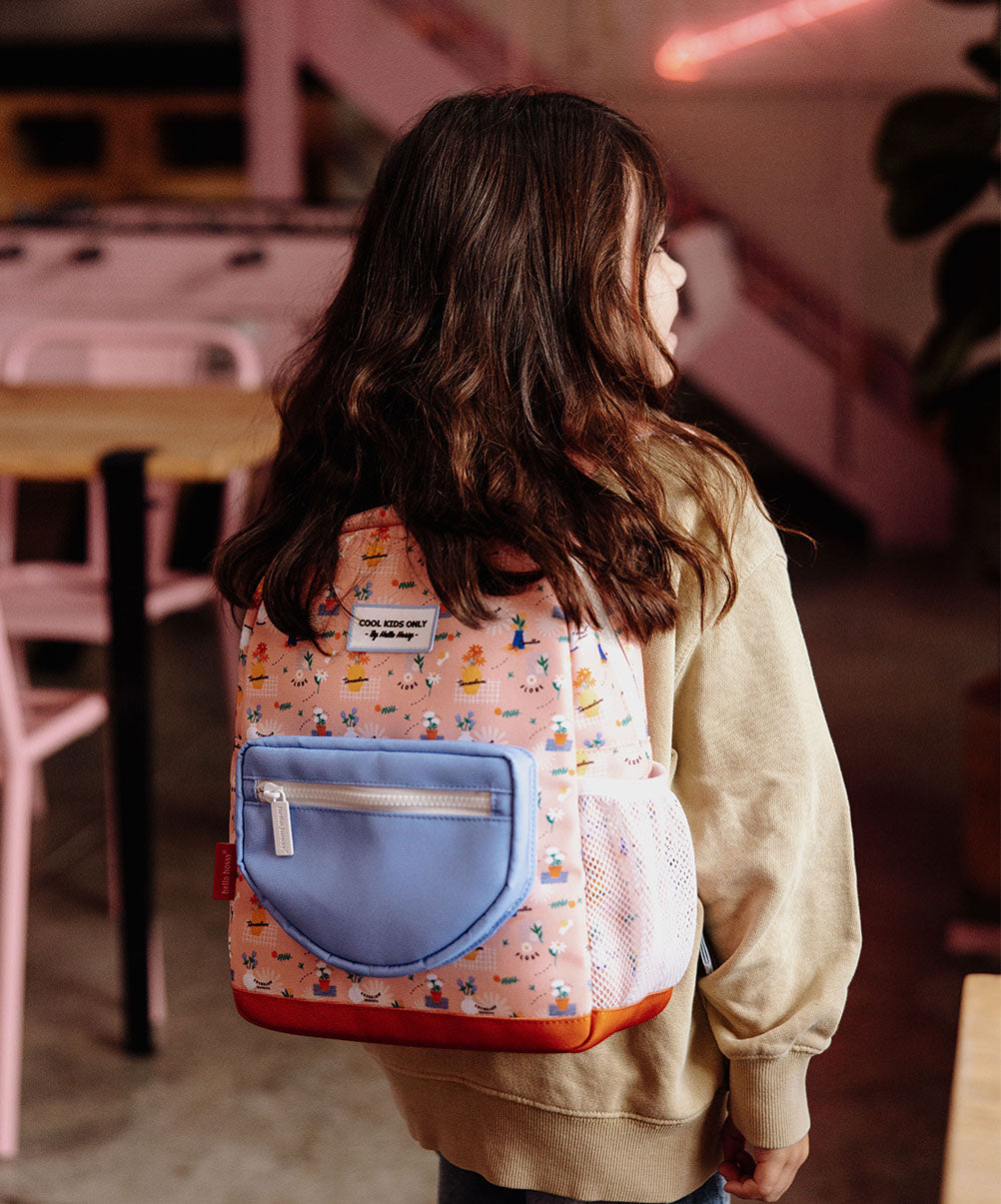 Mochila infantil rosa com estampado de flores, bolso azul, rede branca e detalhe vermelho Hello Hossy