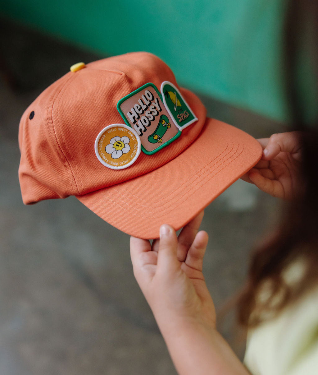 Boné infantil laranja com patch skate e pala curva Hello Hossy