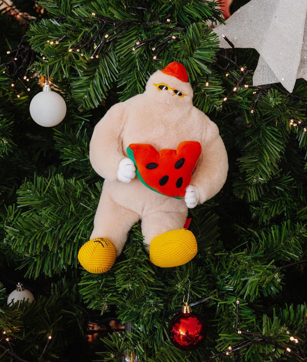 Peluche infantil bege com gorro vermelho a segurar uma melancia vermelha Hello Hossy