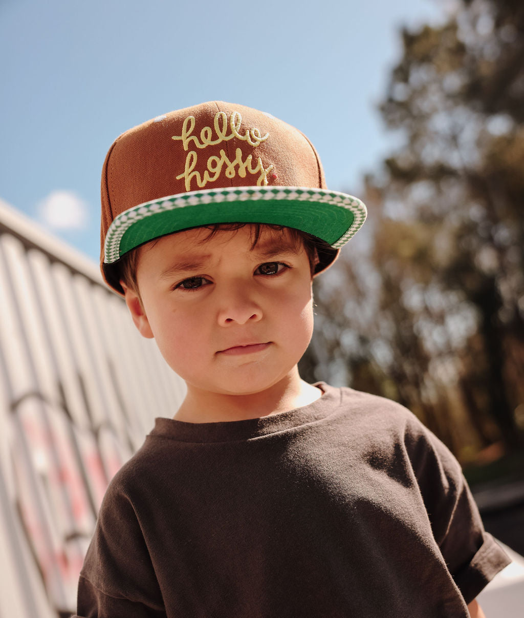Boné infantil castanho com pala reta verde e bordado Hello Hossy