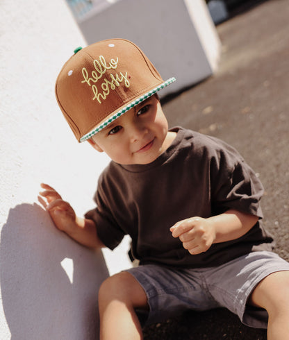 Boné infantil castanho com pala reta, rebordo verde e bordado Hello Hossy