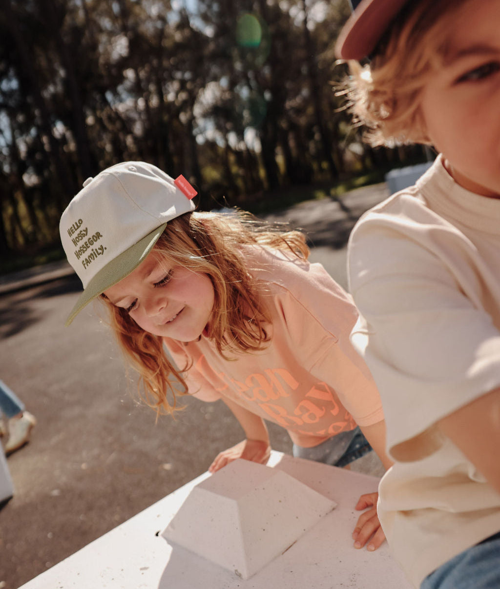 Boné infantil branco com pala verde e texto bordado Hello Hossy