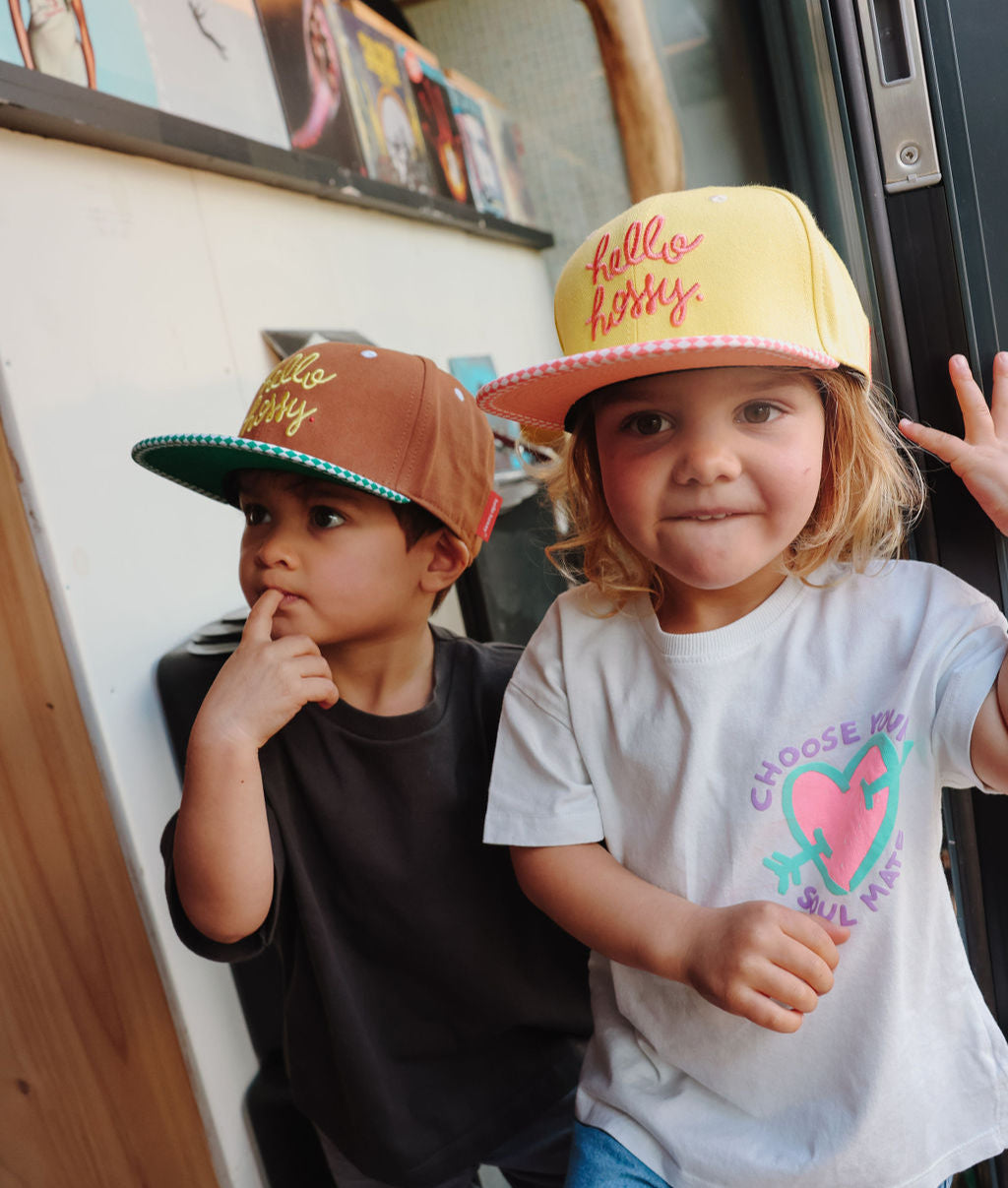 Boné infantil amarelo e rosa, pala reta, bordado Hello Hossy, e boné castanho e verde Hello Hossy