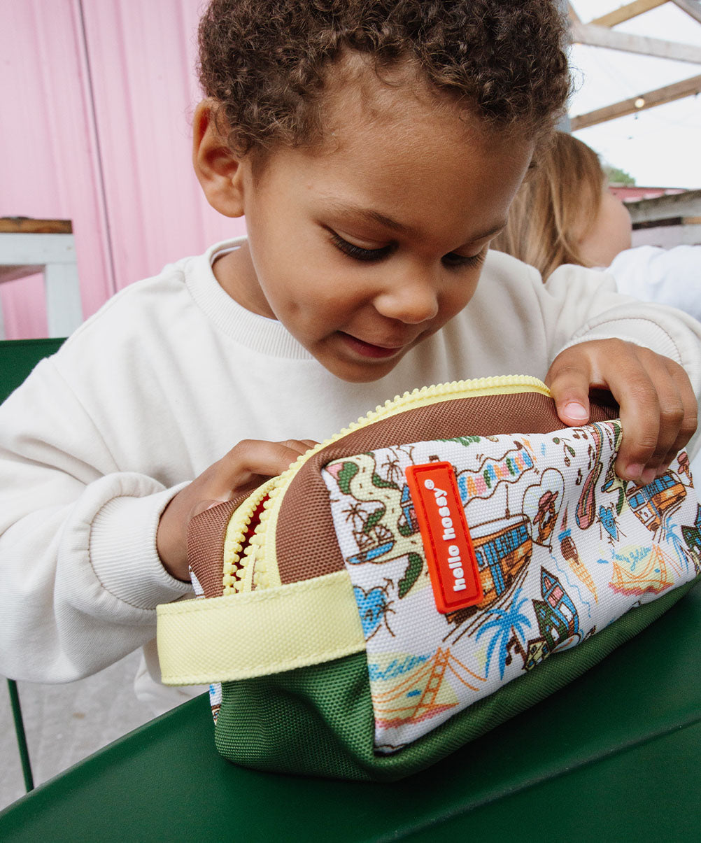 Estojo escolar infantil castanho e creme, padrão viagem, fecho amarelo Hello Hossy