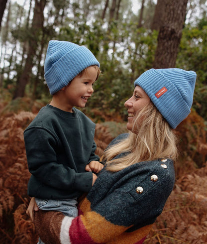 Duo mãe-criança com gorros azuis e etiqueta cosida Hello Hossy