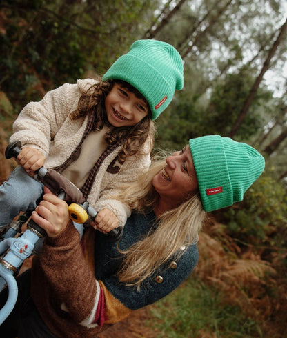 Gorro infantil verde com etiqueta vermelha usado em duo com mãe Hello Hossy