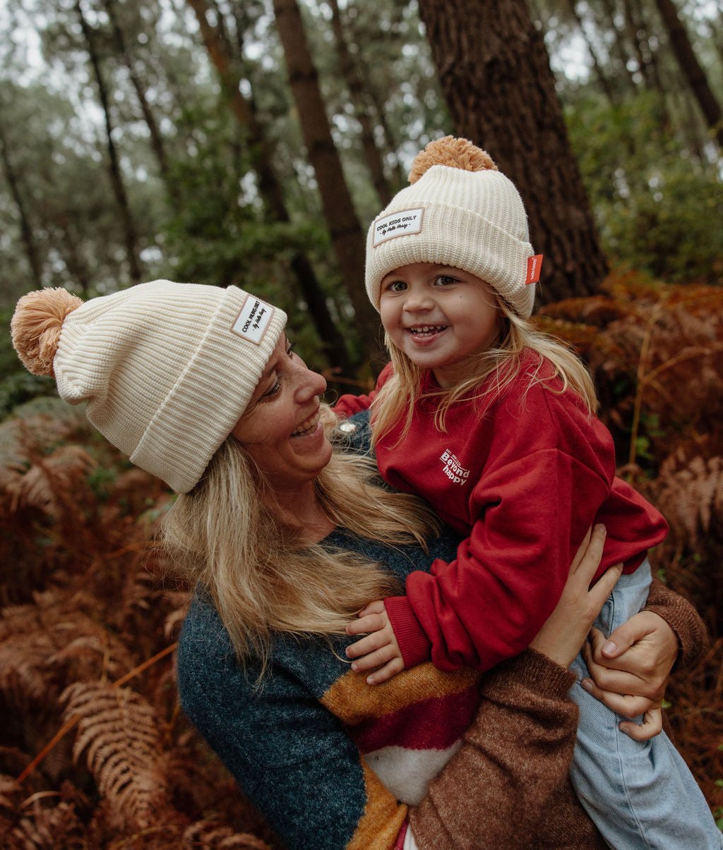 Duo mãe e criança com gorros bege com pompom a combinar Hello Hossy