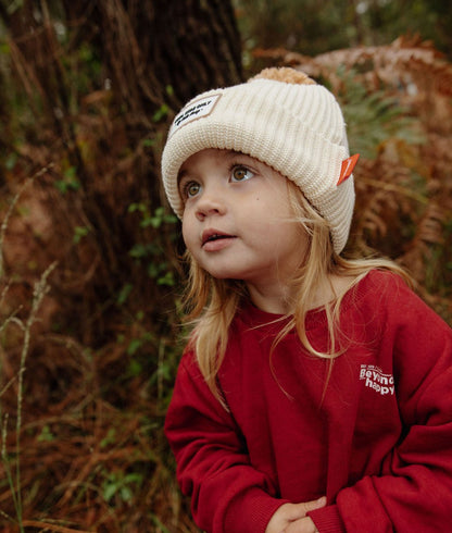 Gorro infantil bege em malha canelada, pompom e etiqueta laranja Hello Hossy
