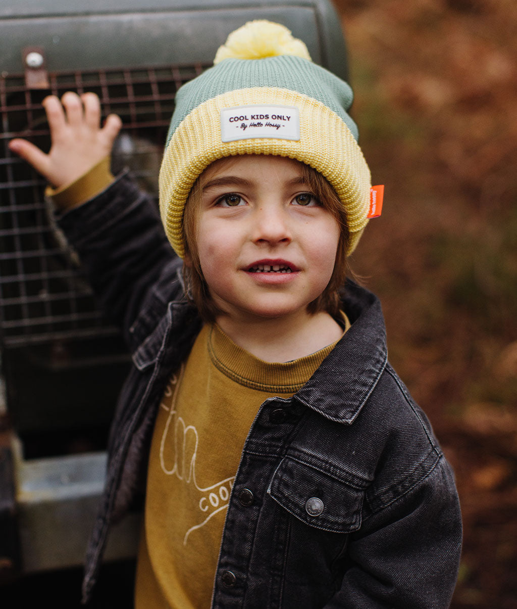 Gorro infantil verde e amarelo com pompom e etiqueta bordada Hello Hossy