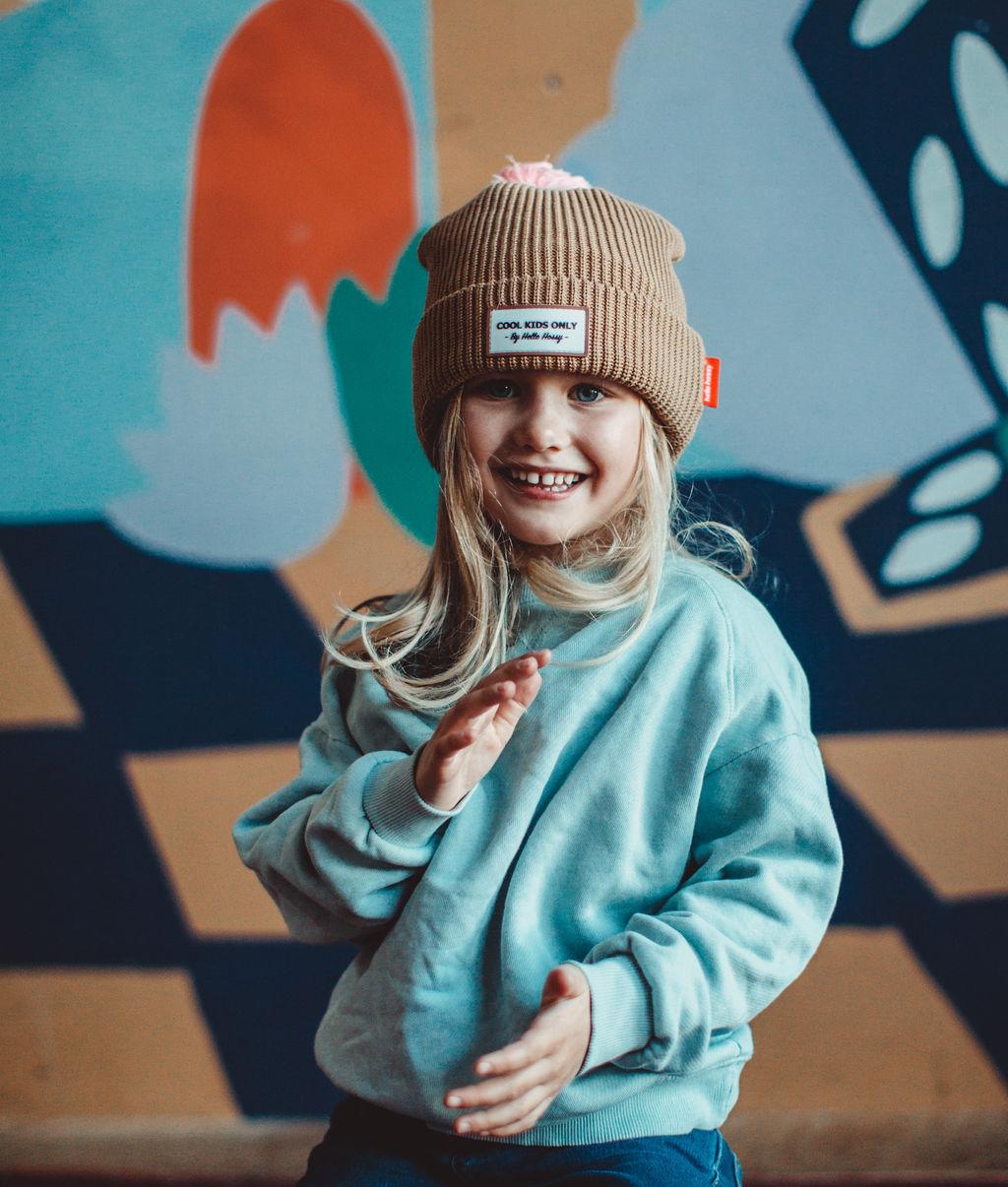 Gorro com pompom Color Block Macaroon usado por uma menina – vista de frente – Hello Hossy