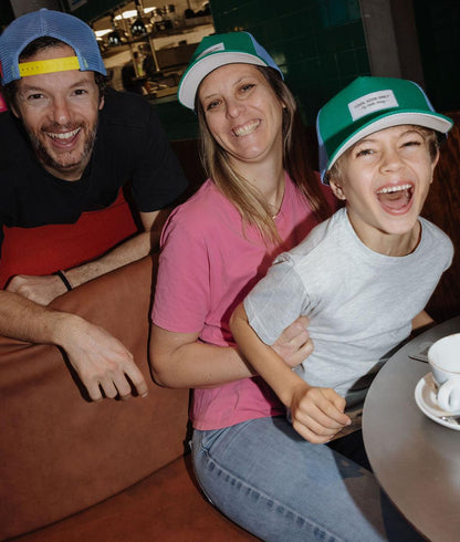 Boné infantil verde e azul com pala curva, usado em família Hello Hossy