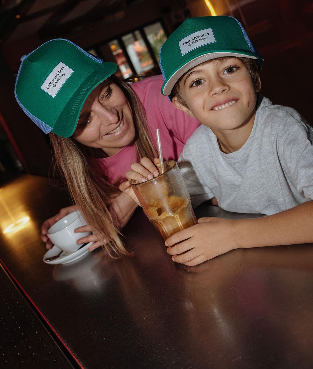 Boné infantil verde e azul com rede traseira, pala curva, usado em duo mãe-filho Hello Hossy