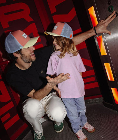 Boné trucker infantil laranja e azul-claro usado por um pai e o seu filho Hello Hossy