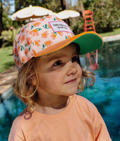 Boné infantil creme com flores, pala laranja, em uso Hello Hossy
