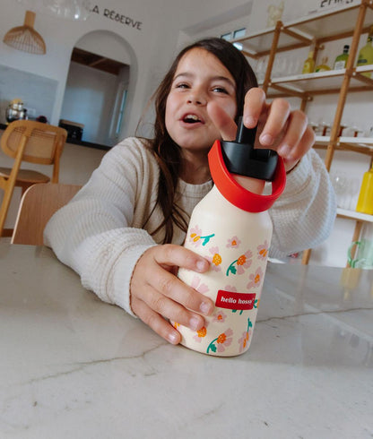Garrafa reutilizável infantil bege com estampado de flores, pega laranja e tampa preta Hello Hossy