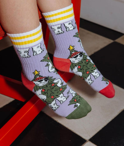 Criança com um par de meias estampadas com urso polar disfarçado de árvore de natal – vista de cima – Hello Hossy