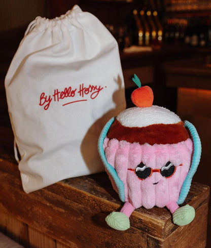 Peluche em forma de bolo Cherry Cake pousada ao lado da sua bolsa reutilizável - foto de ambiente - Hello Hossy