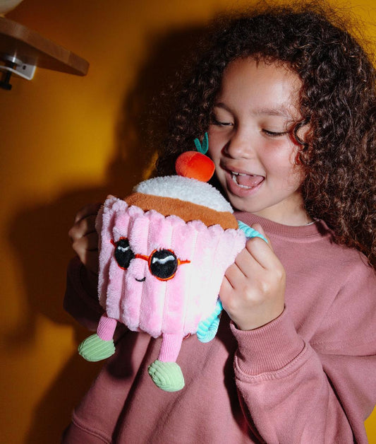 Criança a segurar a Peluche macia em forma de bolo Cherry Cake pelas pegas da sua mochila - foto lifestyle - Hello Hossy