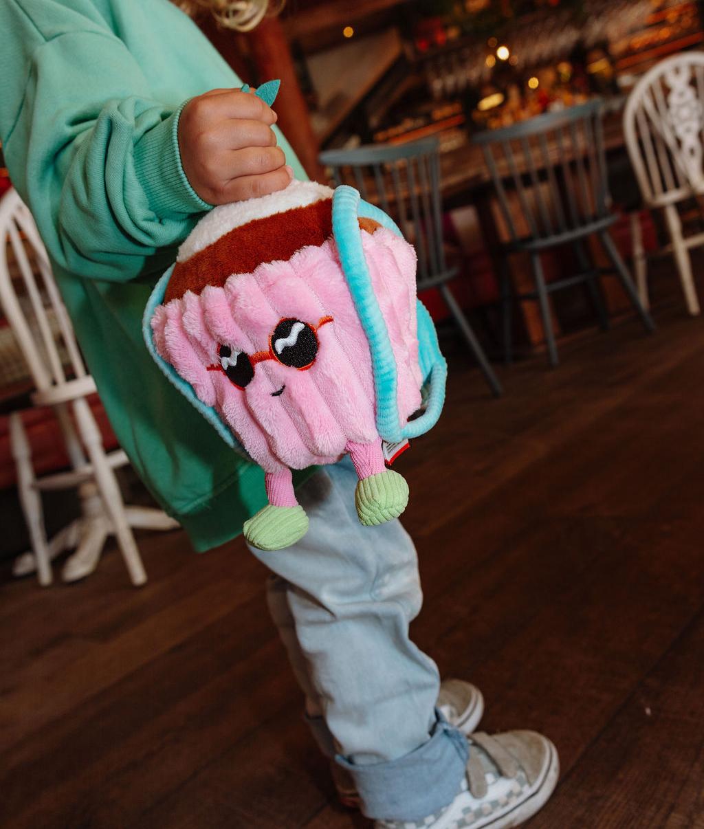 Criança de pé a segurar a Peluche original Cherry Cake - vista de 3/4 - Hello Hossy