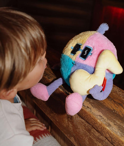 Peluche macia Disco Pop pousada numa rampa com uma criança a olhar para ela - brinquedo original - Hello Hossy