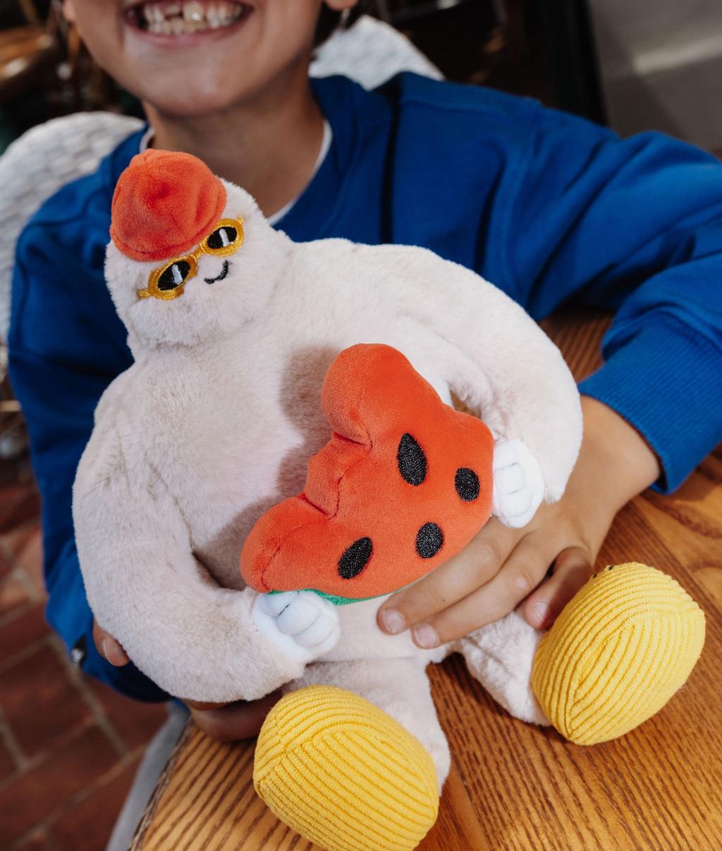 Peluche original em forma de yeti com uma fatia de melancia nas mãos, Frosty Yeti, segurado por uma criança – vista de frente – Hello Hossy