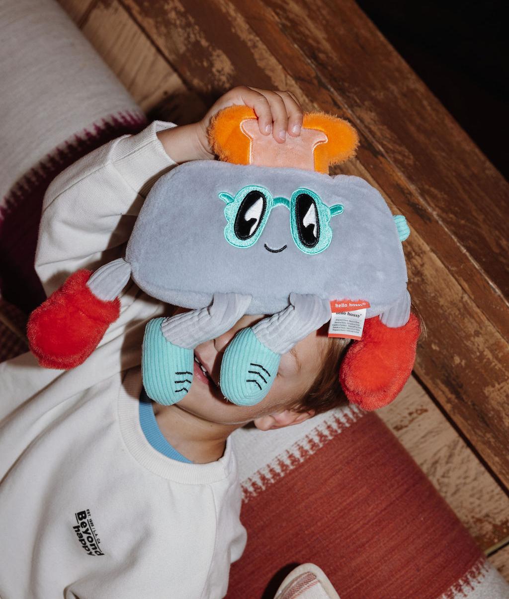 Menino de pé a segurar à frente do rosto a Peluche original Punchy Toast – vista de frente – Hello Hossy