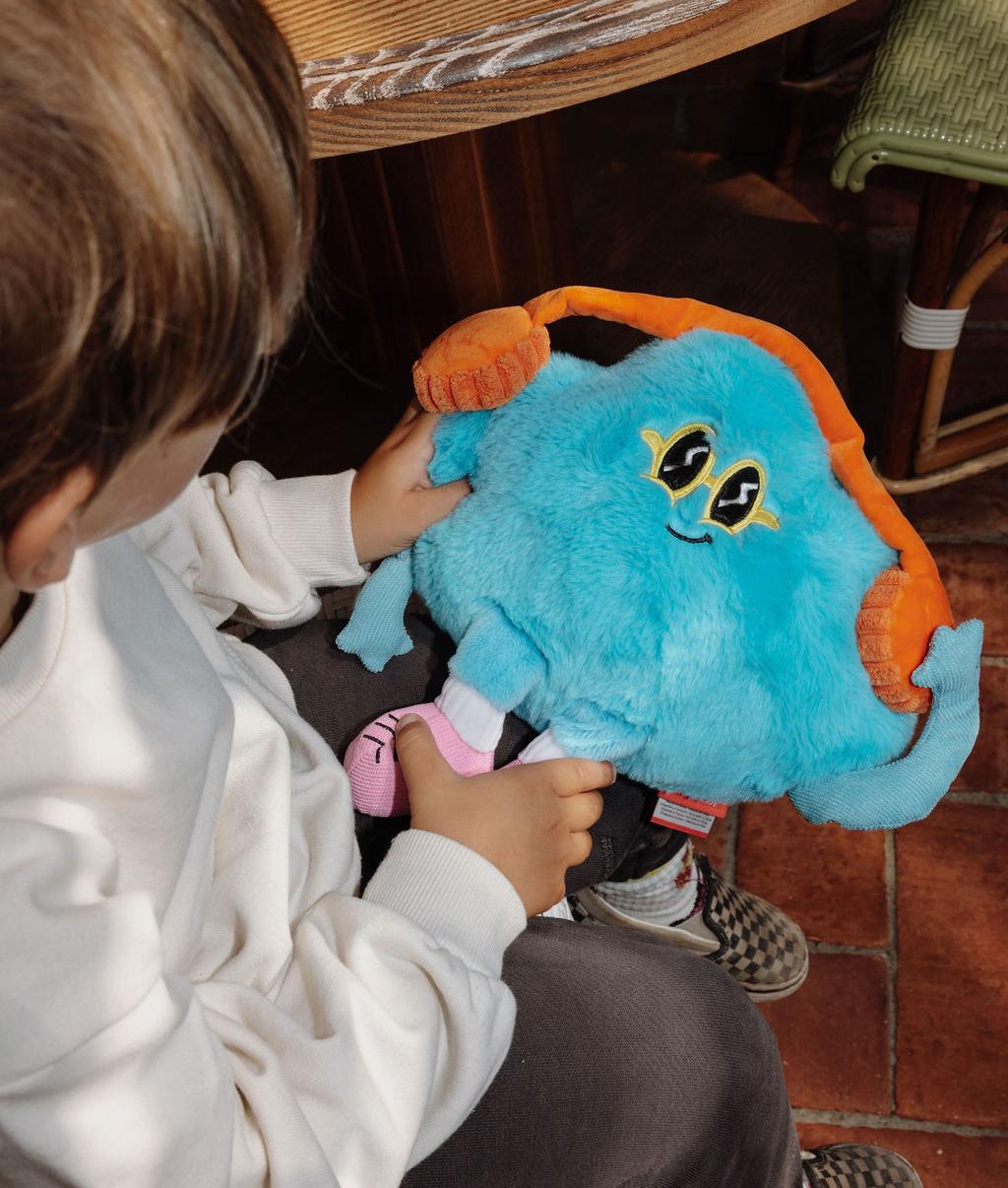 Peluche original em forma de nuvem com auscultadores, Rock N Cloud, segurada por uma criança – vista de cima – Hello Hossy
