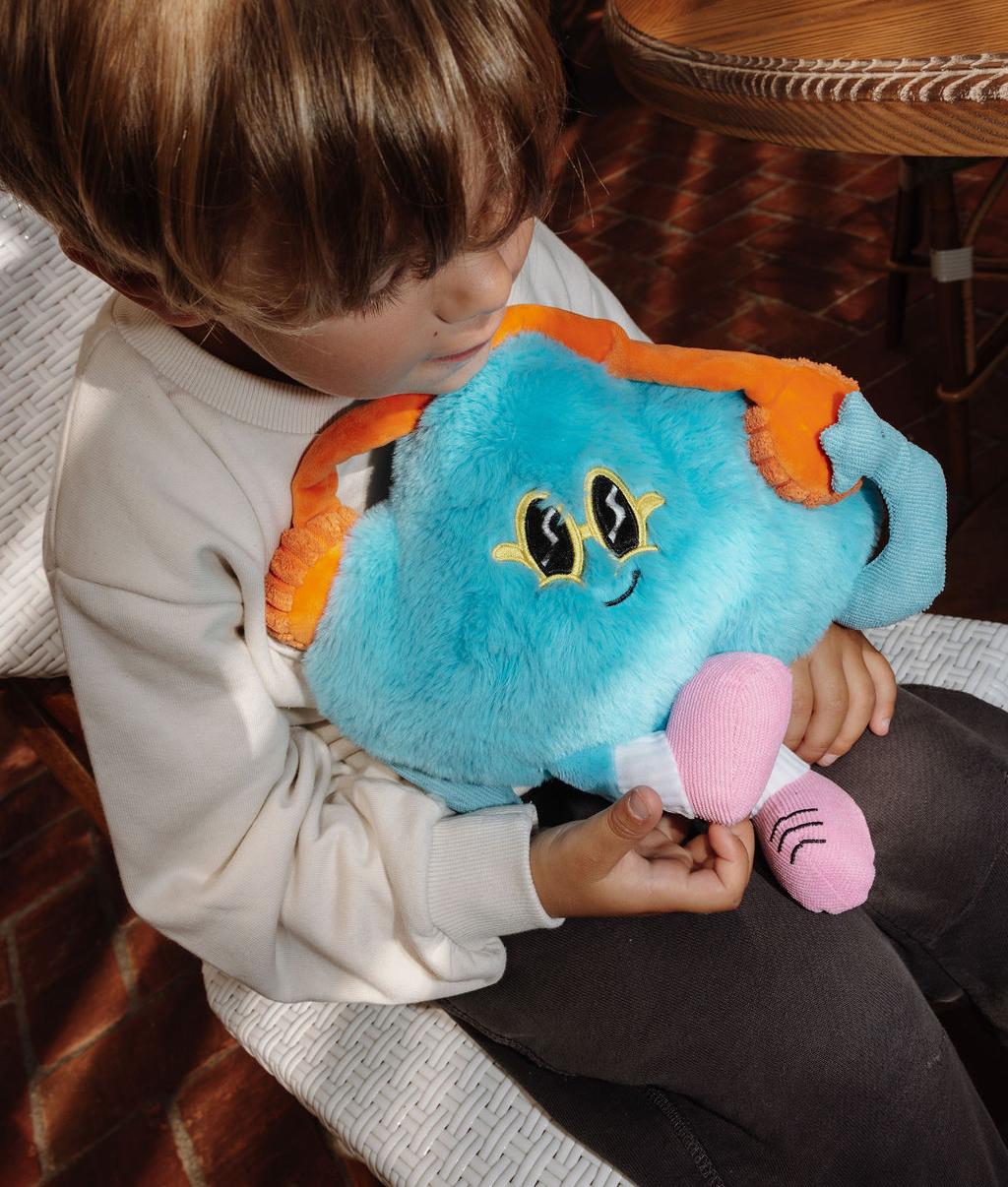 Peluche nuvem azul Rock N Cloud com óculos de sol amarelos nos braços de uma criança - brinquedo original - Hello Hossy