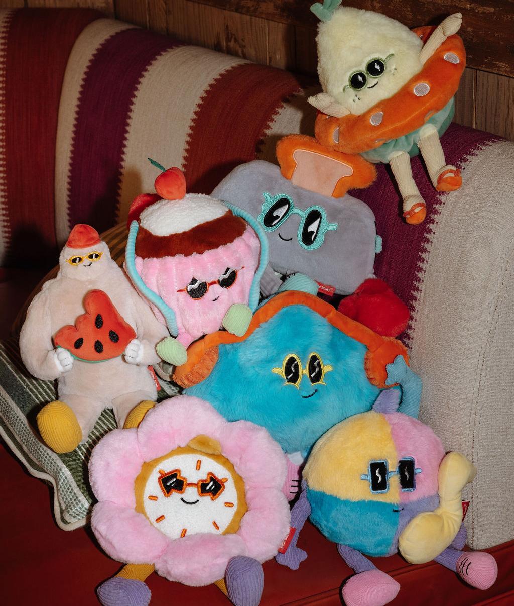Coleção de peluches Hello Hossy empilhados num sofá - foto de ambiente