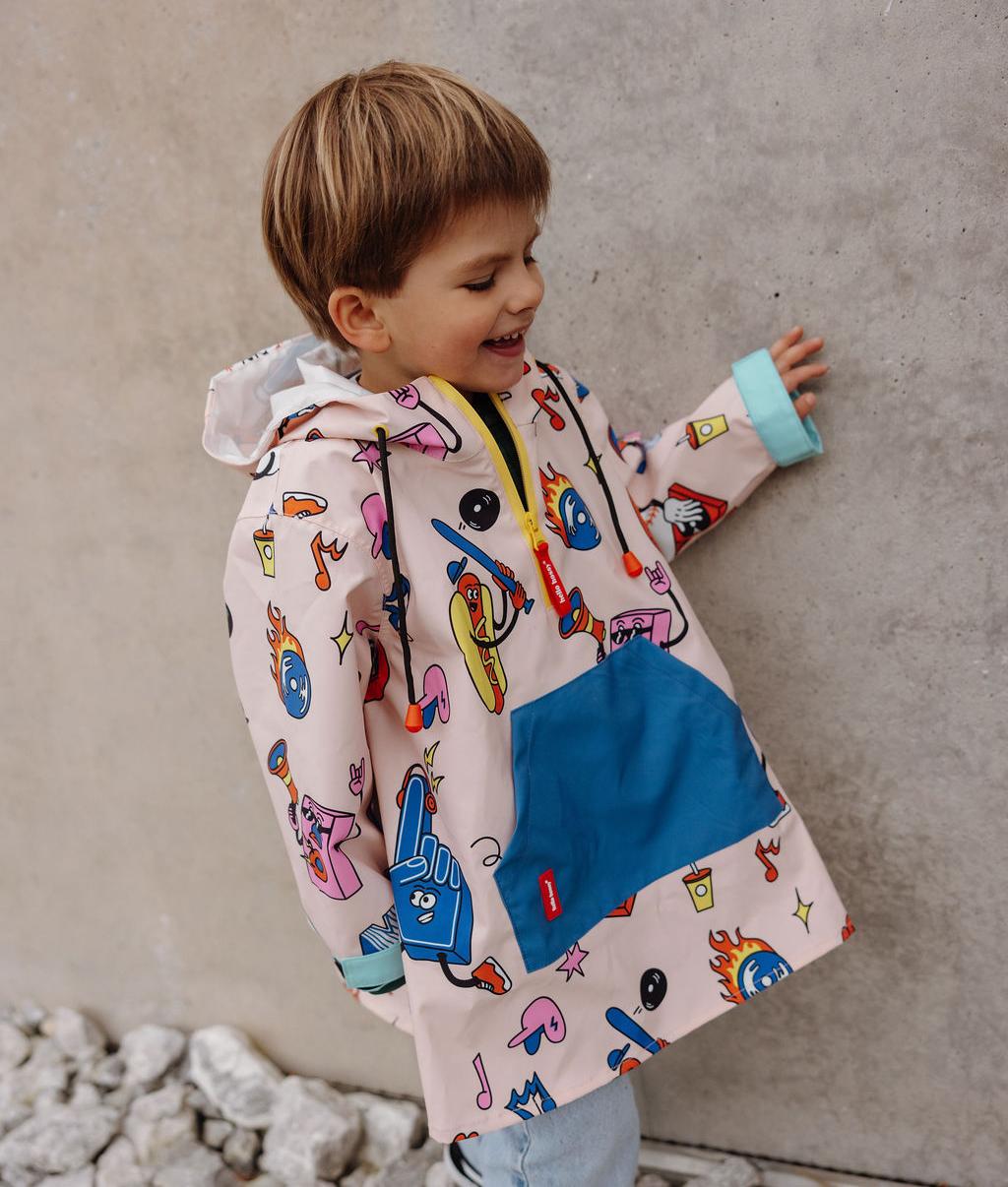 Poncho de chuva infantil creme, azul e vermelho com padrão de desporto, bolsos Hello Hossy