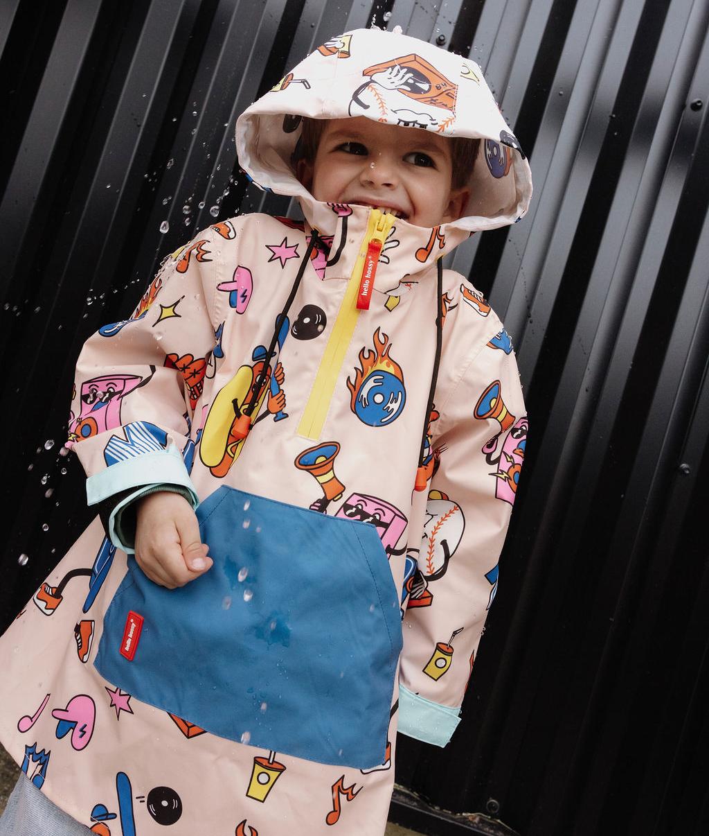 Poncho de chuva infantil creme com estampado de desporto azul e bolso com fecho Hello Hossy