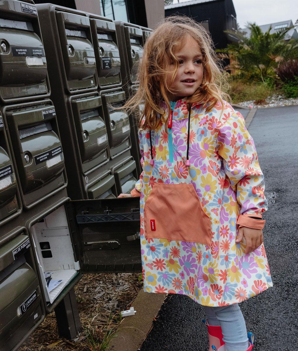 Poncho de chuva impermeável Retro Flowers usado por uma menina - vista de 3/4 - foto lifestyle – Hello Hossy