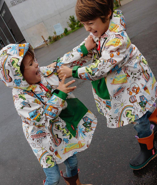 Duo de crianças a usar o poncho de chuva impermeável com capuz San Francisco – vista lateral – Hello Hossy