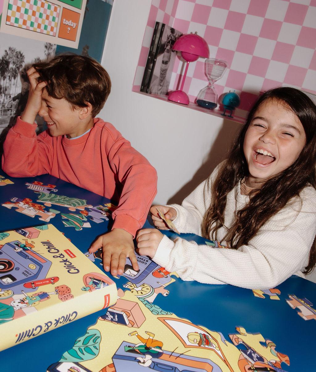 Menina e menino a montar o Puzzle colorido de 36 peças "Click & Chill" numa mesa – ambiente divertido – Hello Hossy