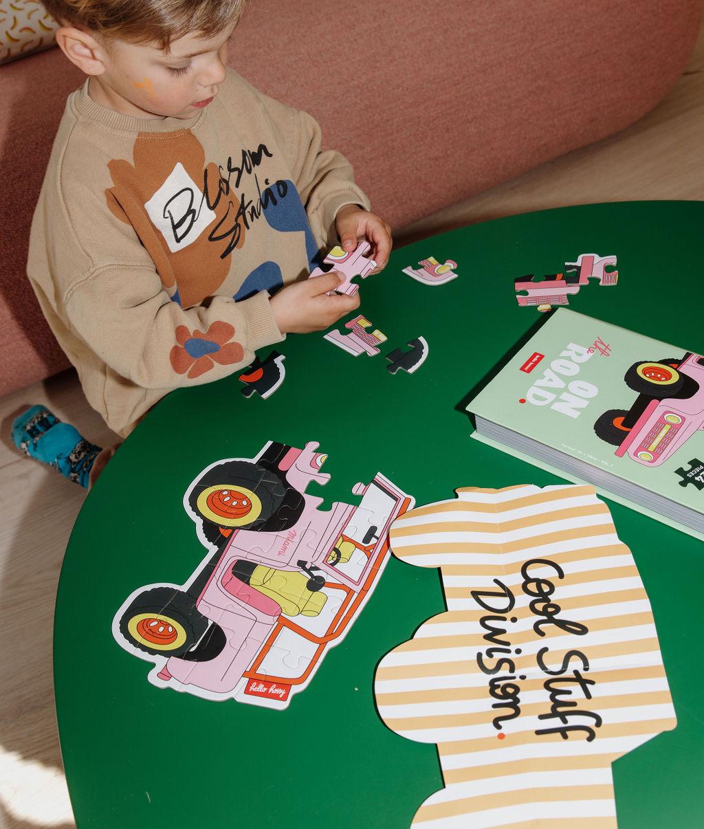 Criança a brincar com o Puzzle de 24 peças "On The Road" – vista de cima – Hello Hossy