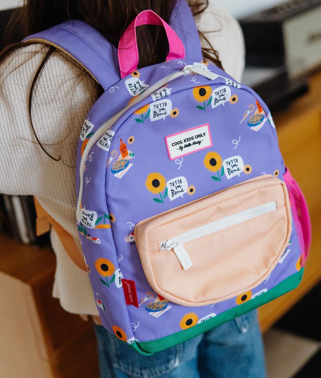 Mochila infantil violeta com padrão de flores, painel com texto Hello Hossy